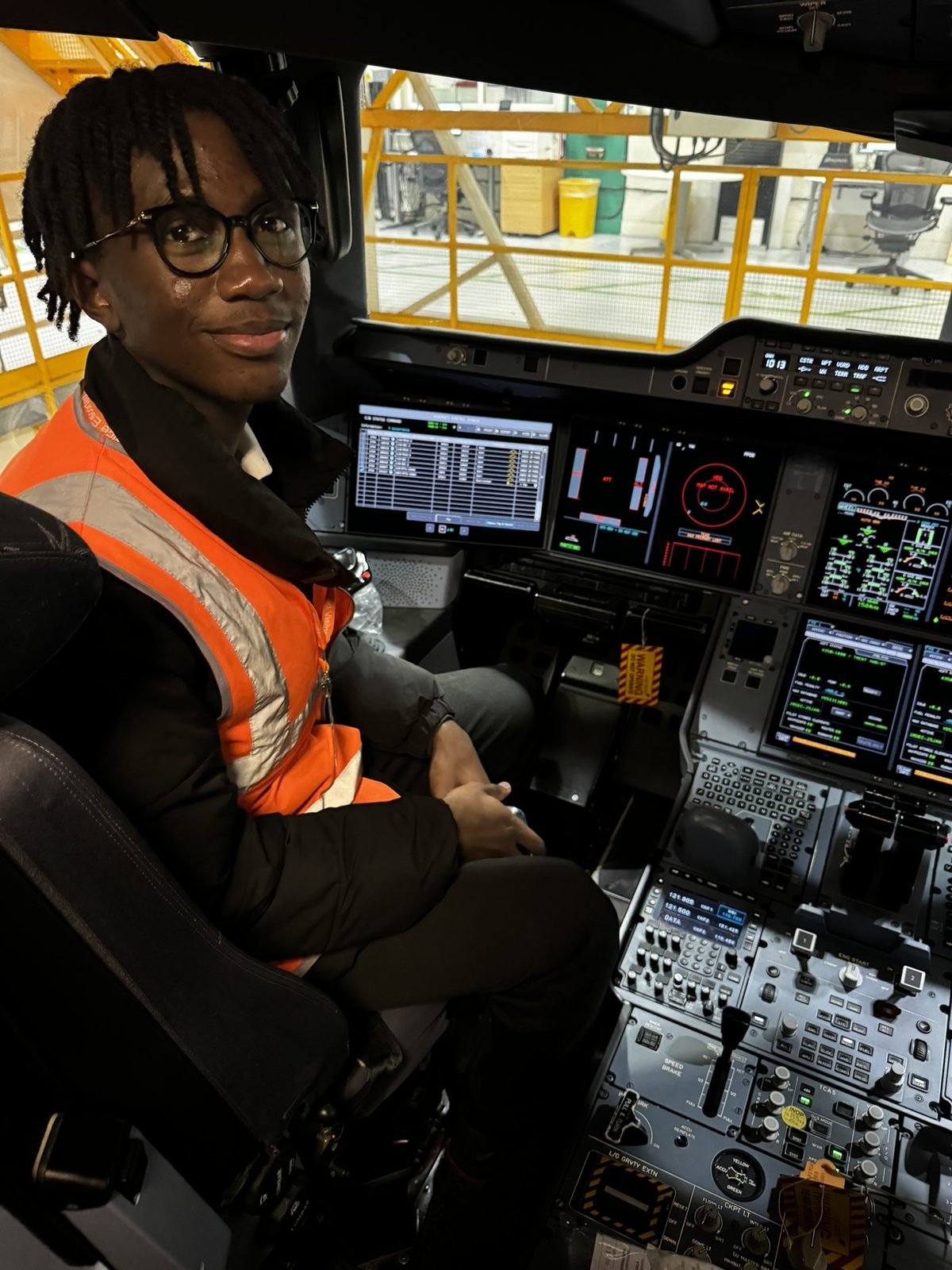 Kobi in a high-visibility vest in the captain's seat of an Airbus A350