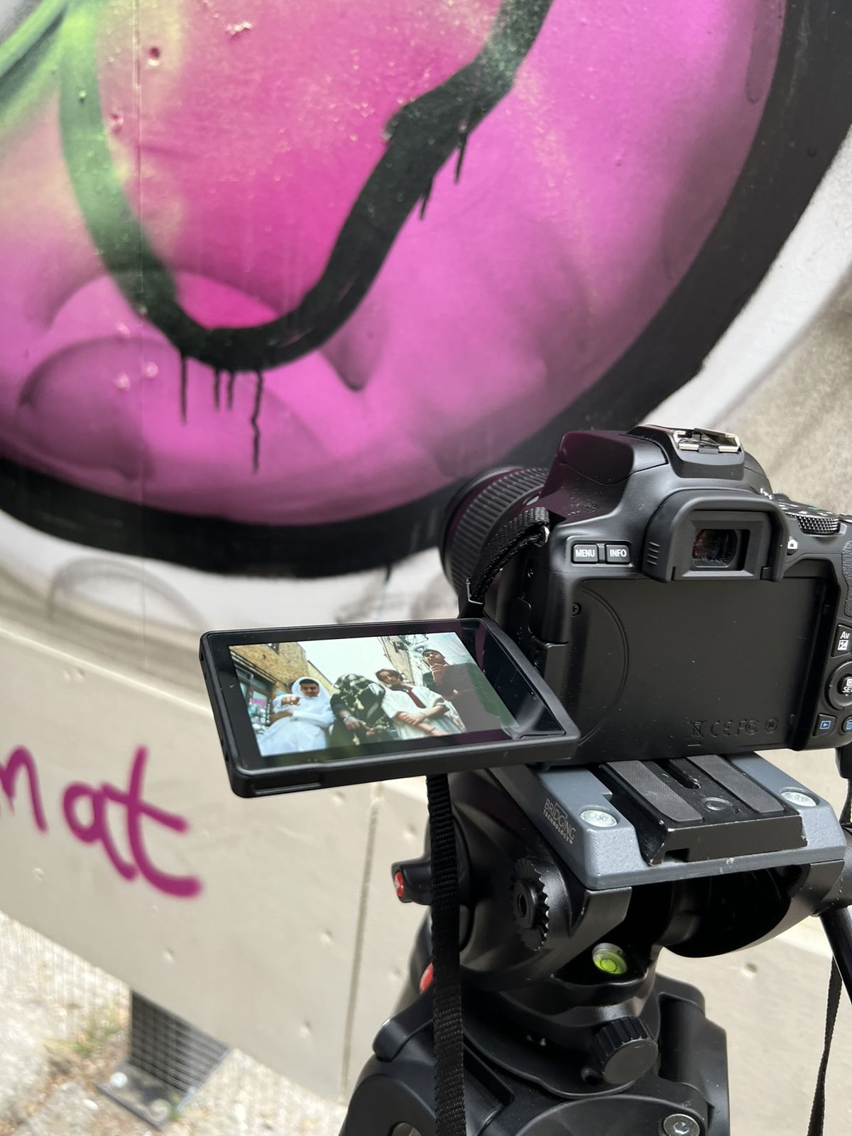 A camera on a tripod framing a music video shot