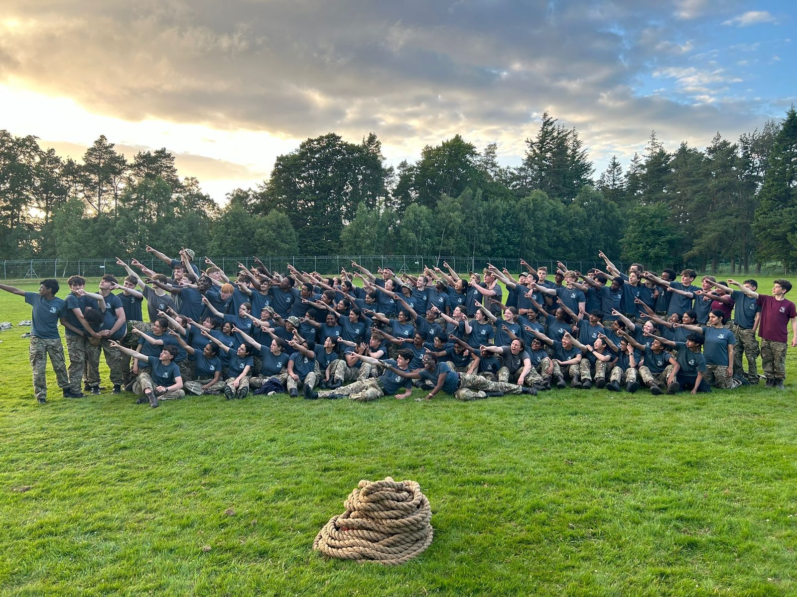 Kobi's Combined Cadet Force contingent in a group photo on a field at sunset