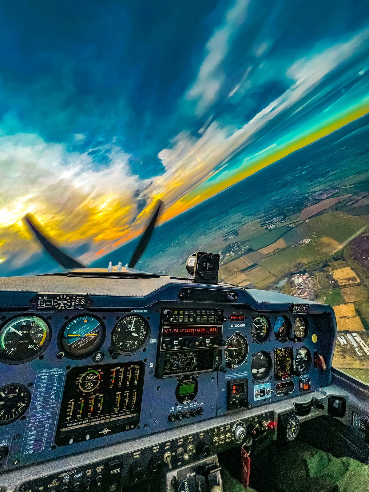 View from the cockpit of a Grob G103 Twin Astir in a steep banked turn over fields