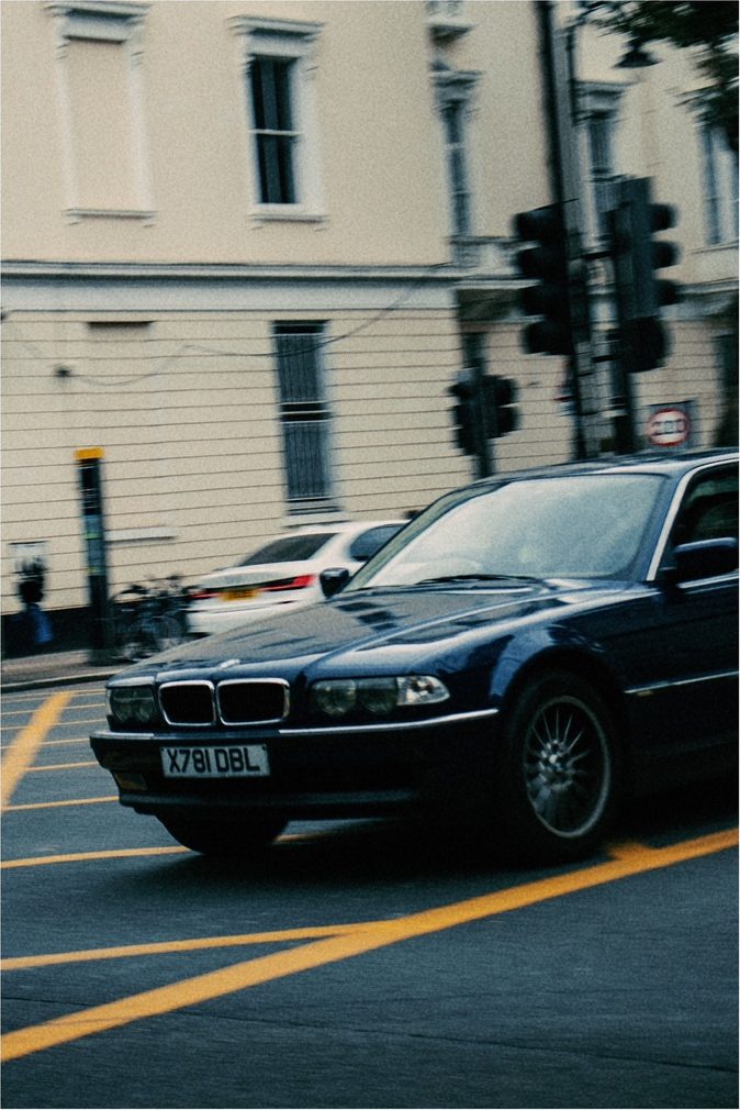 A dark blue BMW 7 Series turning through a London junction