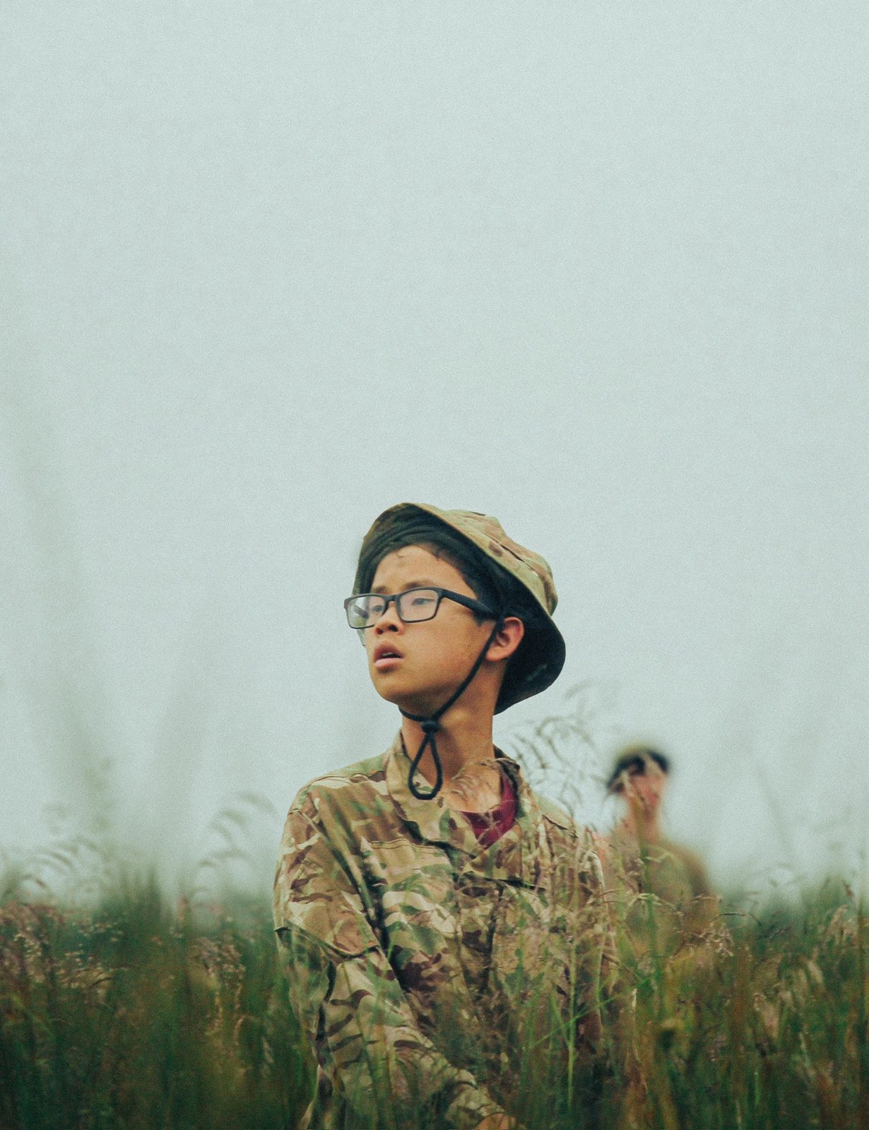 A cadet in a bush hat looking out across the grassland at Otterburn