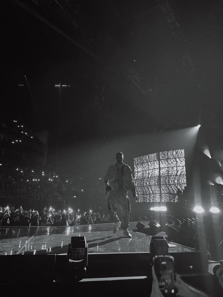 Black and white shot of an artist walking the stage in an arena