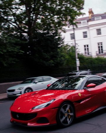 A red Ferrari passing on a London street