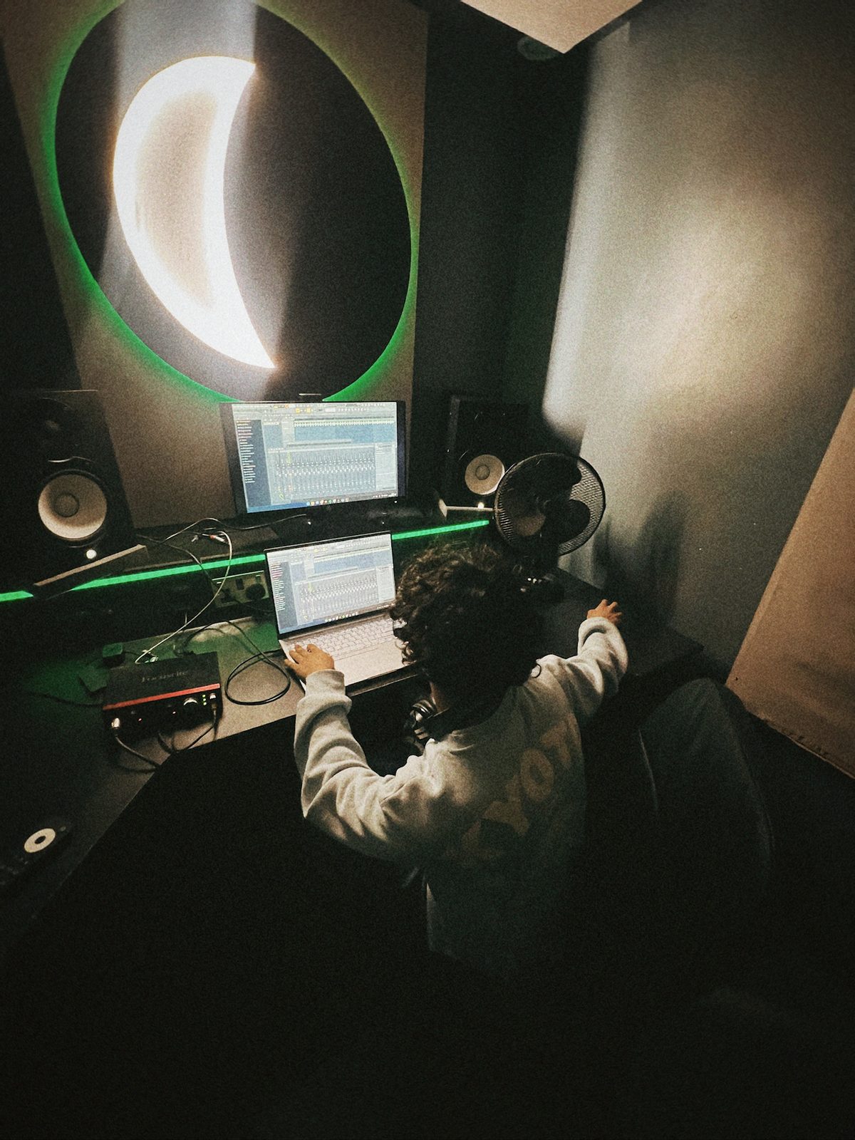 Working at the desk in a dark studio lit by a crescent moon light
